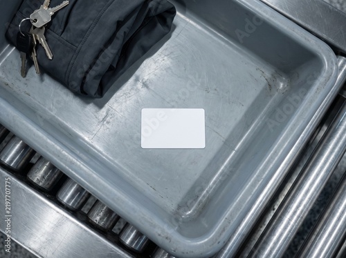 Blank white card in gray security tray with jacket and keys