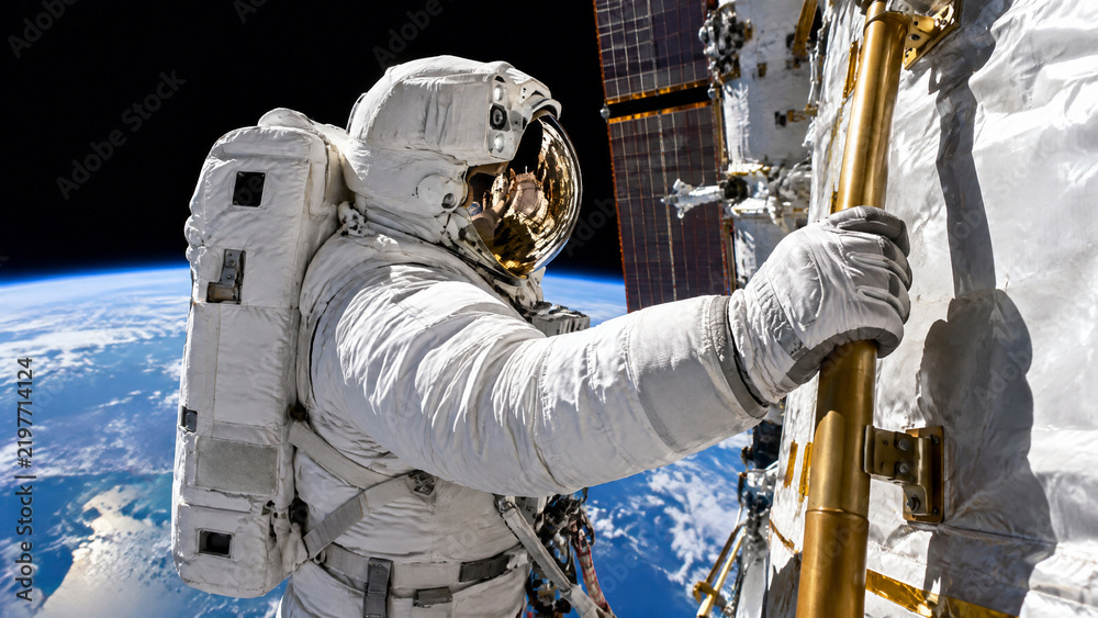 Fototapeta premium Astronaut Performing Spacewalk Maintenance Outside Space Station, Extravehicular Activity in Orbit Above Curved Blue Earth Planet Horizon