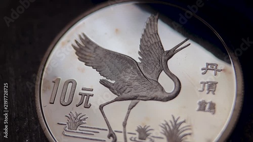 Chinese silver coin featuring an elegant crane in a wetland setting, with detailed feather relief, engraved Chinese characters, reeds, polished metallic surface, and refined numismatic craftsmanship.
