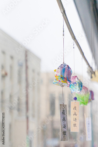 Fotografie Colorful glass wind chimes hanging in a snowy street in Otaru