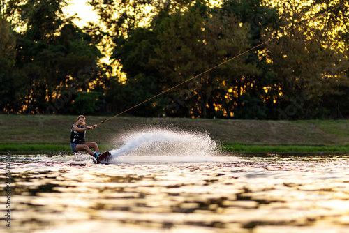 Photography Female wakeboarder wakesurfing on sunset
