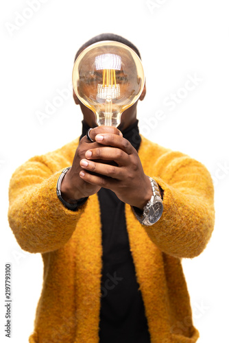Quadro su tela Person holding large light bulb to symbolize innovation, ideas, and creativity i