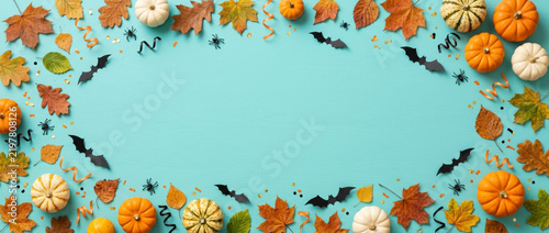 Autumn Halloween frame with pumpkins, leaves, bats and spiders on blue background.