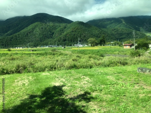 Photography Green Japanese countryside with fields and forested mountains