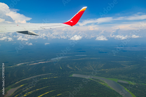 Aerial view of the Amazon River winding through the vast rainforest of Peru, photographed from an airplane window.