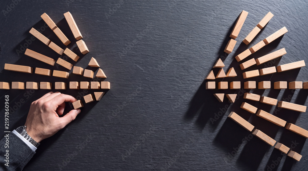 Obraz premium Businessman hand arranging small wooden blocks into arrow shapes on dark stone surface for strategic business planning, leadership development, direction, and growth vision concept.