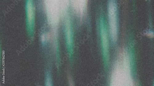 Abstract cool light leaks forming a dark grainy film texture