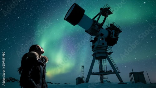 Woman watches aurora borealis with telescope under starry night sky and northern lights