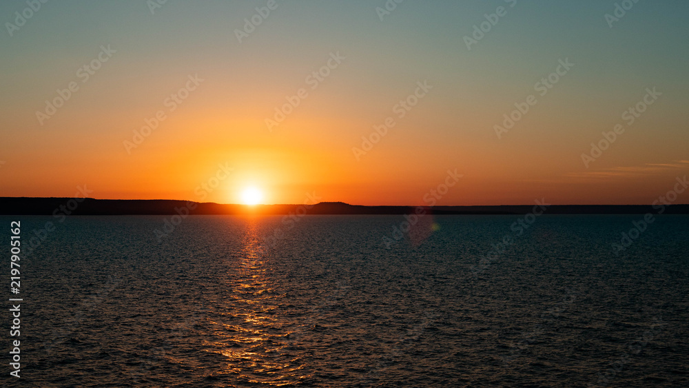 Fototapeta premium beautiful sunset at sea calm water ocean red orange colours