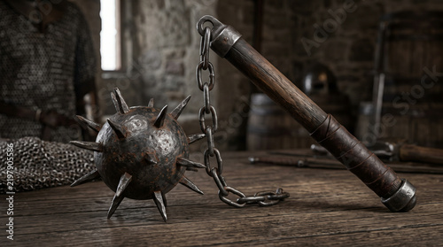 Rustic medieval morningstar weapon with chain resting on weathered wooden surface in dimly lit workshop