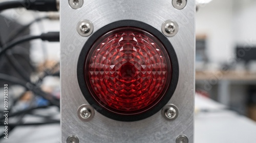 Industrial control panel with a prominent red indicator light and screws