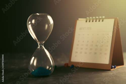 Hourglass and calendar on table. Time management concept.