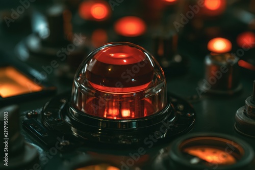 Close-up of a glowing red emergency warning light on a vintage control panel