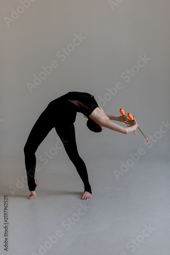 Obraz na płótnie Flexible teen gymnast executing backbend element holding bright rhythmic gymnast