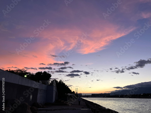 Fotografía 夕暮れ時の紫色の空が広がる川沿いの遊歩道