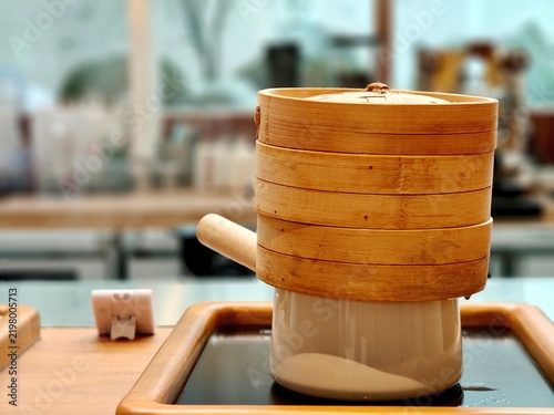 Obraz na płótnie Stacked bamboo steamer on ceramic pot in a modern kitchen, showcasing traditional Asian cooking and steam food preparation