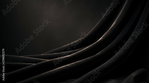 Abstract dark background with smooth black wavy lines and soft light reflections