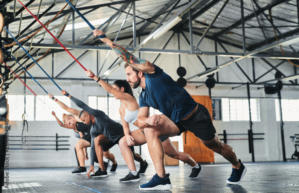 Obraz premium Gym, group and people stretching for fitness, bodybuilding or exercise for muscle development. Health club, workout and warm up with team for training, preparation and together with personal trainer