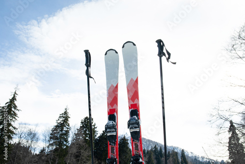 Fotografía Ski poles and skis positioned against a backdrop of snow-covered mountains