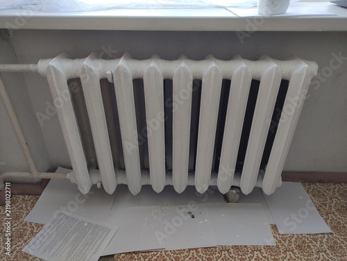Freshly painted white cast iron radiator with new coat of paint in a room