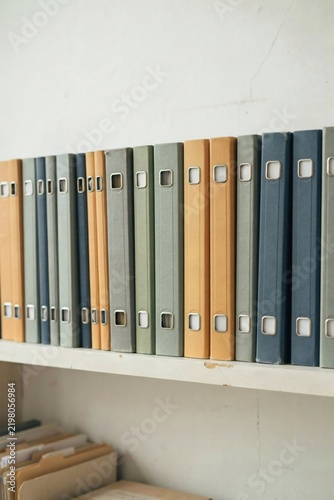 Shelf of ring binders with blank spine labels in a plain office archive