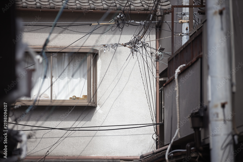 Obraz premium Window and tangled cables on a plaster wall of an old Japanese house, Osaka