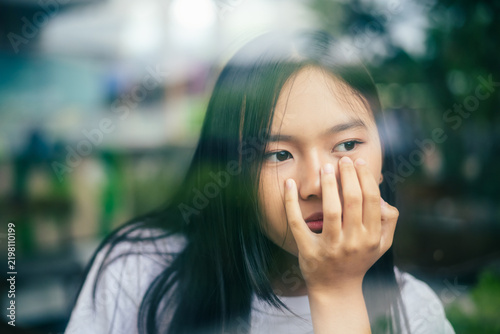 anxious worried teen girl with her smartphone as a conceptual backdrop for cyberbullying social media trauma, teenager mental health crisis, depression and panic attack