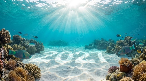 Underwater view of coral reef with the year 2021 written on the sandy ocean
