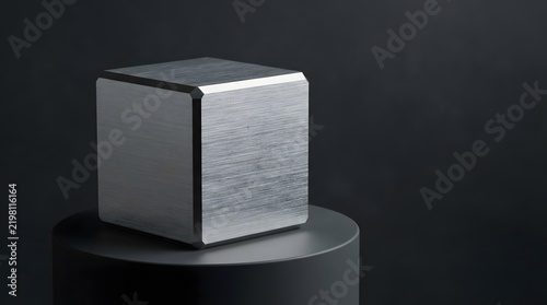 Minimalist metallic cube on dark pedestal in studio lighting
