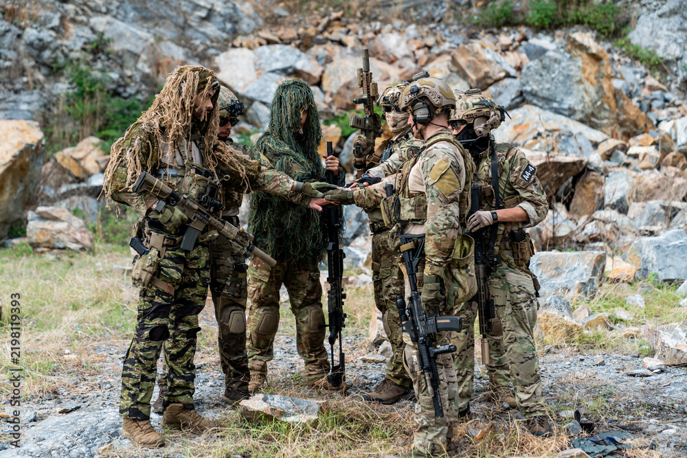 Fototapeta premium Soldiers prepare for an operation during training in a rocky outdoor area