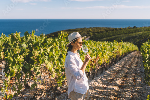 Woman tasting wine in coastal vineyard