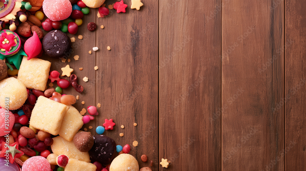 Obraz premium Festive Holiday Treats Arrangement Inspired by the Vibrancy of Carnaval de San Miguel Featuring Colorful Candies and Cookies on a Rustic Dark Wood Surface