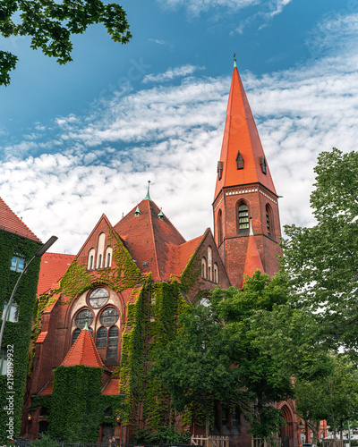 Historic Red Brick Church with Tall Spire and Ivy