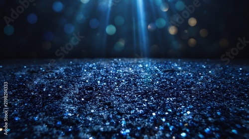 This dazzling dark blue glitter background features a sparkling textured surface illuminated by dramatic spotlights streaming down, creating a moody, magical, and festive atmosphere for holiday.