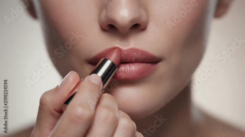 Close-up of Woman Applying Nude Lipstick with Rose Gold Tube