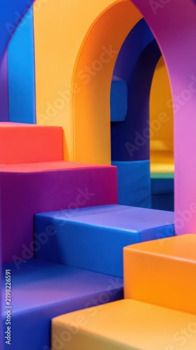 Vibrant geometric shapes form playful steps and arches in a colorful, modern space