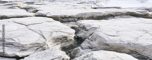 Cracked dry earth surface with deep fissures in an arid landscape background