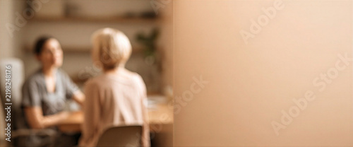 Soft focus consultation between healthcare professional and older adult in warm clinic interior, creating calm supportive atmosphere for wellness care and communication