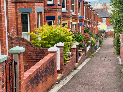 Traditional British Red Brick Terraced Houses and Narrow Alleyway with Front Gardens