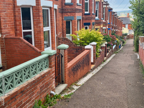 Traditional British Red Brick Terraced Houses and Narrow Alleyway with Front Gardens
