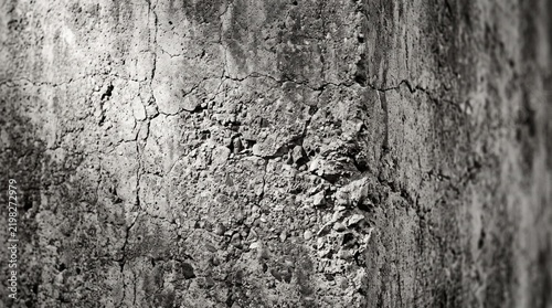 Monochrome close-up of a textured and cracked concrete wall