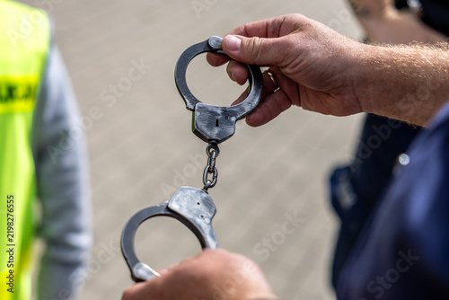 Obraz na plátne Kajdanki w rękach policjanta dla przestępcy