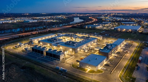 Overhead aerial drone view of datacenter complex illuminated at night modern city infrastructure