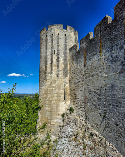 Obraz na płótnie Impressive medieval stone tower and fortified rampart wall of Château de Beaucaire built on a rocky cliff under a clear blue sky in Gard, France