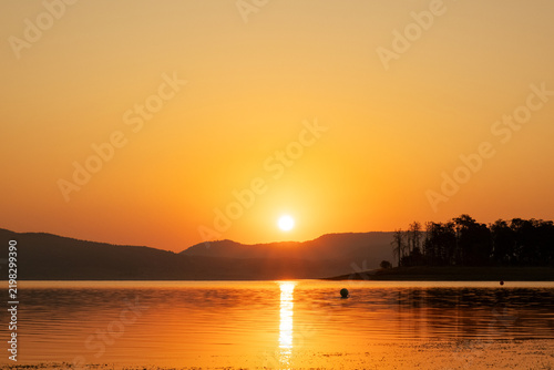 Bright Sun Rising Over Lake Mountain Silhouette Reflection On Water Surface Golden Hour Morning Panorama Batak Reservoir Bulgaria Scenic Nature