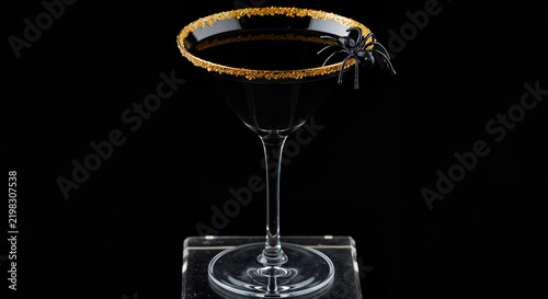 Black cocktail with spider decoration on a dark background  
