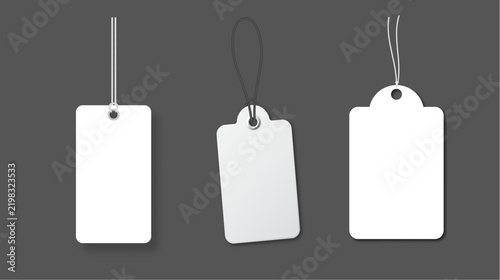 Set of three blank rectangular price tags with strings, hanging labels for clothing or gifts, realistic empty paper tags a dark grey background