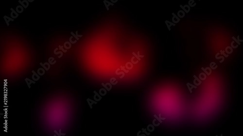 Blurred red and pink light spots glowing on black background. Abstract bokeh lights moving in darkness. Neon glow effect for backdrop overlay