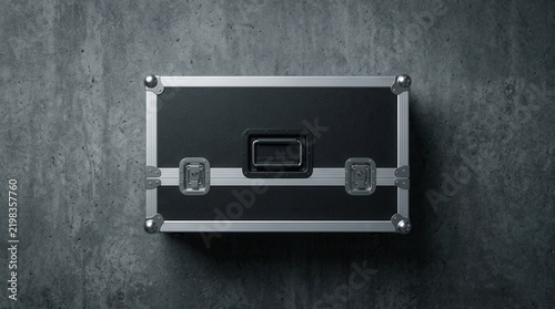 Concrete wall background featuring a professional black road case with metal corners