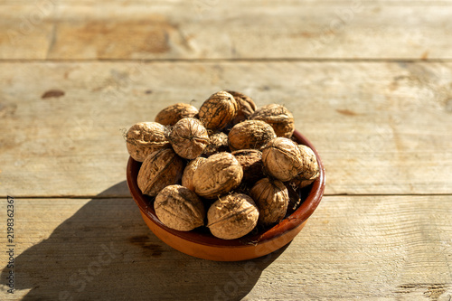 Fresh Uncracked Walnuts in Terracotta Bowl with Autumn Sunlight